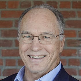 a portrait of Dr. Charles DeCarli wearing eyeglasses, blue shirt and dark jacket. 